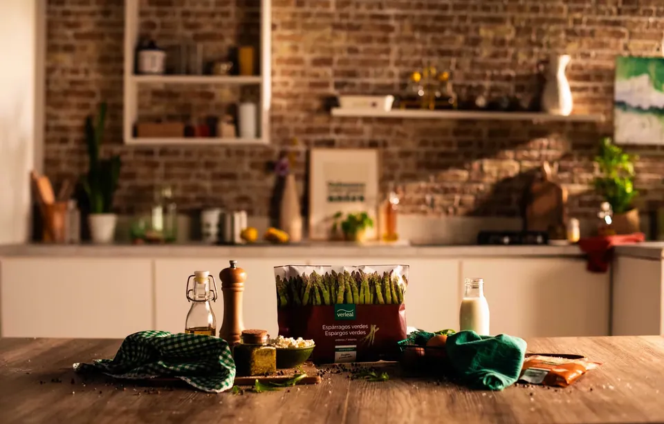 Cocina con pared de ladrillo y verduras sobre la mesa.